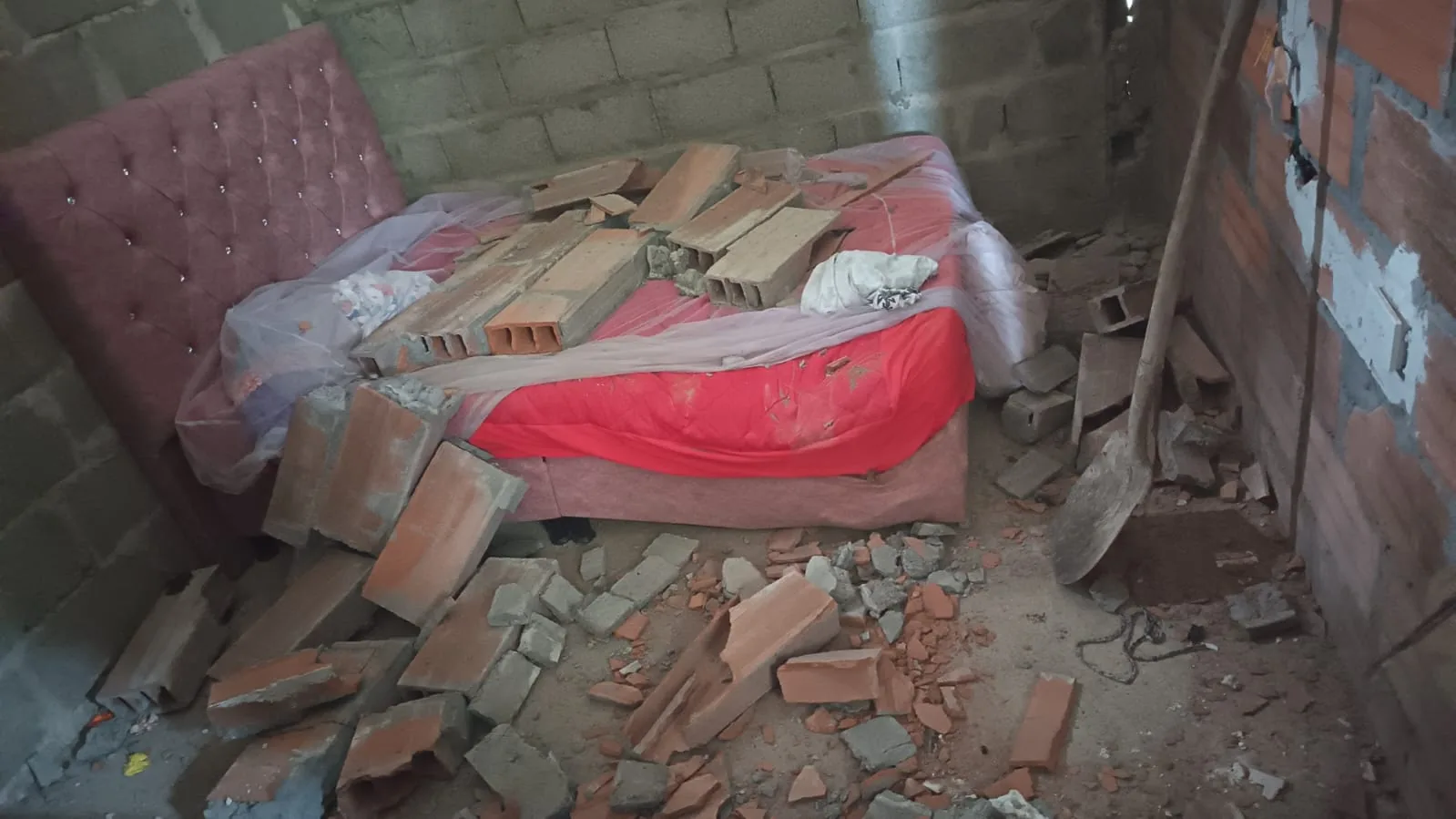 Beschadigde slaapkamer met brokstukken na de aardbeving